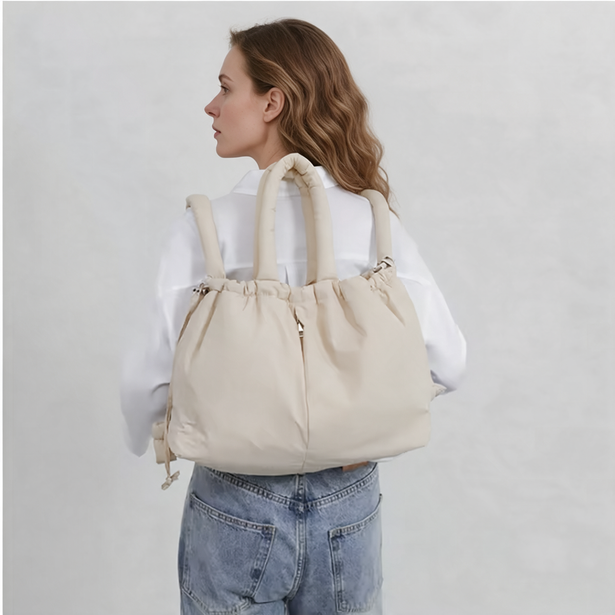 Olise Cloud Bag in ecru worn as a backpack, back view